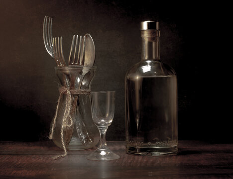 Stylized still life with a bottle of vodka or moonshine with a glass