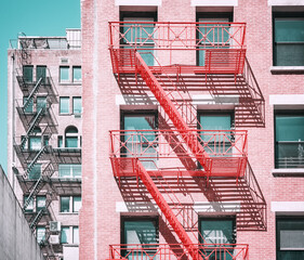Fototapeta na wymiar Old buildings with fire escapes in New York City, color toning applied, USA.