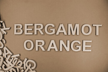 BERGAMOT ORANGE in wooden English language capital letters spilling from a pile of letters in sepia