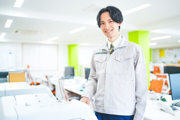 オフィスでコピー機を使う若いエンジニアの男性