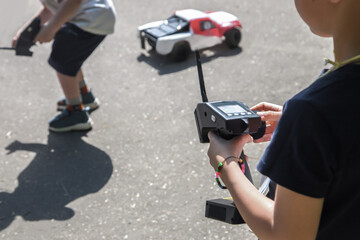  teen boy with electric remote control car toy play outdoor on sidewalk