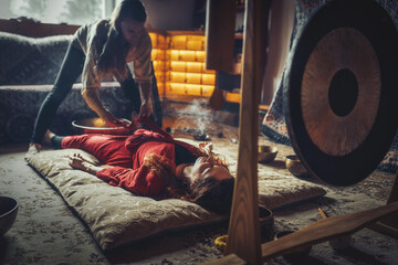 beautiful woman playng on tibetan bowl. Woman on music therapy. ceremonial space.
