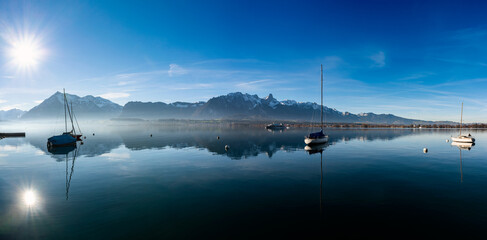 Panorama with boats on a Swiss lake near the mountains