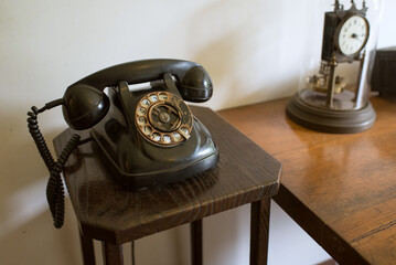 ダイヤル式の黒電話と電話台　昭和レトロ　Black retro telephone on table