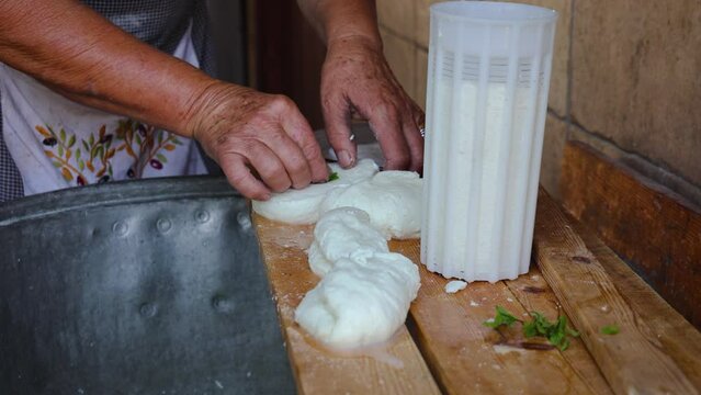 Mrs Sofia cuts Halloumi chesse in Sofia And Andreas Traditional House in Letymbou village, Cyprus