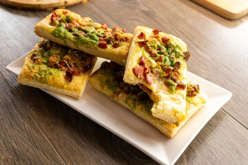 mini slices of puff pastry pizza on a wooden background. Food concept. Bakery.