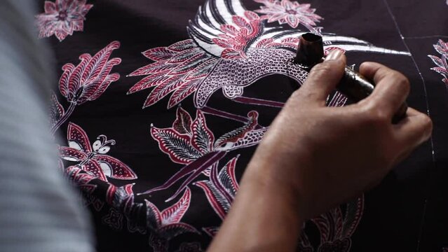 Batik, Close Up hand and canting, making Batik Tulis Indonesia. Canting is tool for drawing the texture on the fabric.
