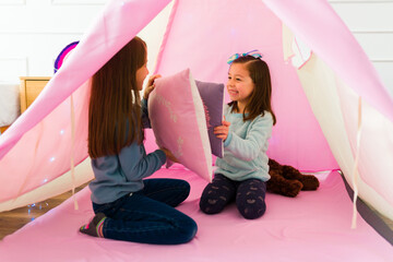 Cheerful little girls playing having a pillow fight