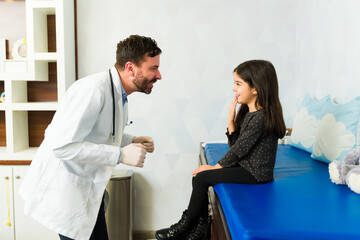 Obraz premium Cheerful doctor having fun with a kid patient