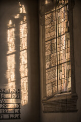 Gotisches Kirchenfenster mit Licht und Schatten und Psalmen an Wand