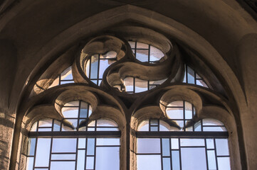 Gotisches Kirchenfenster mit Maßwerk, Bleiverglasung  und Mosaik im Gegenlicht in Neckartenzlingen