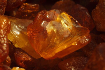 Close-up of raw amber resin with rich golden tones and natural texture. Ideal for themes of...