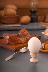 Boiled chicken egg on the background of a piece of smoked meat and fermented vegetables. Close-up