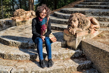 todi, italien - frau sitzt auf treppe mit steinlöwen im stadtpark