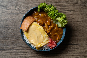 Japanese curry chicken omelette isolated with wooden table background