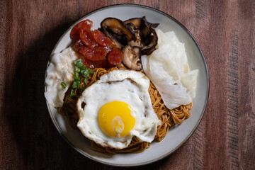 Homemade dry Wonton noodle (Wan Tan Mee) with isolated brown background.