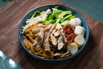 Homemade dry Wonton noodle (Wan Tan Mee) with isolated brown background.