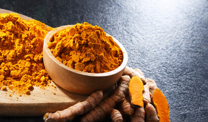 Composition with a bowl of ground turmeric and its fresh rhizome