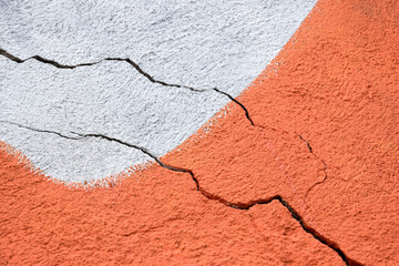 Two big winding descending crack on old multicolored plastering wall. Copy space. Selective focus.
