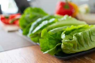 young woman preparing lettuce As an ingredient in breakfast menu and ready for cooking healthy meals and on table there are also vegetables that are organic ingredients that help maintain healthy diet