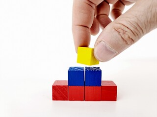 Abstract multicolored 3d pyramid chart on white background, with hand of mature man.