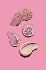 Skin care cream, face serum swatch smear on pink background. Transparent gel serum  product smudge swipe closeup. Transparent drop of gel on pink background.