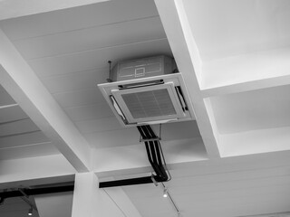 Ceiling mounted cassette type air conditioner decoration near the lights on white concrete...