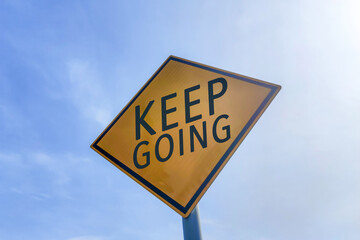 Keep going motivational message on road sign.