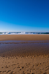 Peaceful and beautiful coast of Portugal. Beautiful ocean beach landscape. Blue sky. Sand.