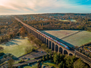 UK Commuter Train Travelling Across a Viaduct at Sunset