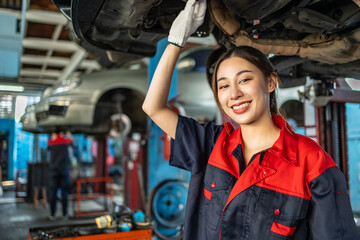 Fototapeta na wymiar Asian automotive engineer people wear helmet work in mechanics garage.young auto mechanic in uniform is looking at camera and smiling examining car.