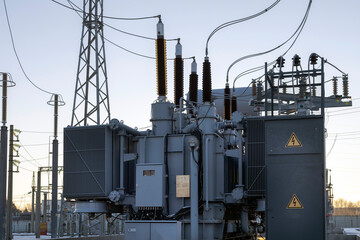 Power transformer at the substation with the rays of the morning sun. Energy. Cold winter dawn at...