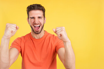 Fototapeta premium Happy caucasian man celebrating while raising fists