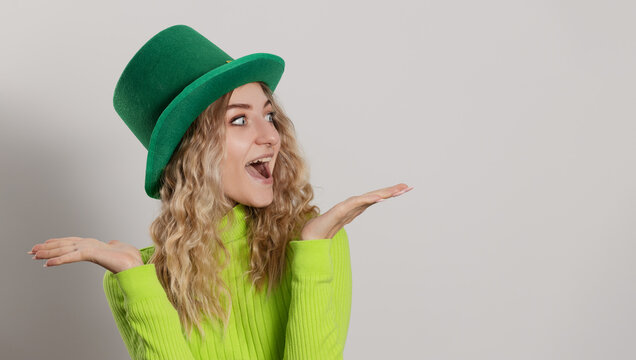 St. Patrick's Day leprechaun model girl in green hat  isolated on white background and smiling, having fun. Patrick Day pub party, celebrating.