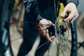 Mechanic repairman assembling wheel disc brakes custom bicycle in workshop