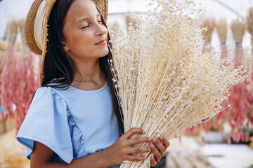 Cute little girl with decorative dried ears of corn