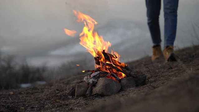 Outdoor recreation. Man collecting branches and twigs from ground for campfire during winter camping, building bonfire in nature for preparing food. Hiking tourism