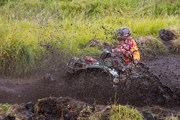 athlete on a quad bike rides in the mud
