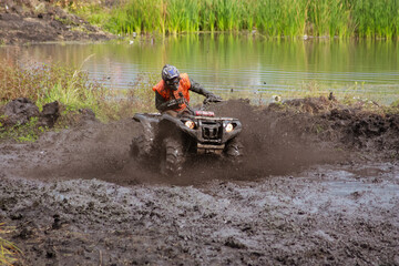 athlete on a quad bike rides in the mud