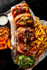 sandwich Set bruschetta with tuna, cheese, roastbeef, vegetables and french fries on a dark wooden board.