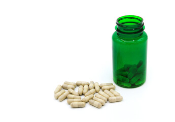 White pills or capsule with green pill bottle isolated on white background with copy space for add text. Healthy, herb, container object and Medicine. Food supplement for cure or repair health