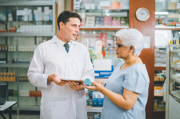 Pharmacist giving advice And advice for patients who come to buy Medicine, Drugs, Vitamins products, according to prescriptions in modern pharmacies.