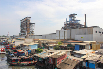 Fototapeta premium portrait of t fishing village beside industrial factory