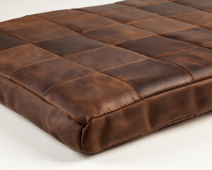 Hand-stitched floor mattress of square pieces of brown leather