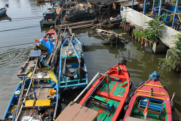 portrait of traditional fishing boats on a dirty river
