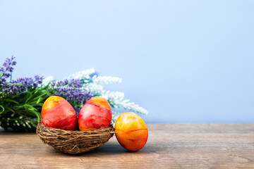 Three Easter eggs in a decorative nest of sisal on a wooden background. Happy Easter concept. Greeting card.