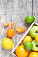 Winter citrus fruits on wooden background with blank space, top view