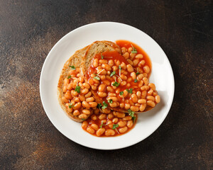 Baked beans on toast in tomato sauce on white plate