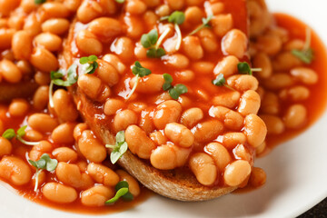 Baked beans on toast in tomato sauce on white plate