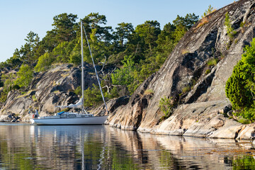 Sailboat anchored near remote rocky island in Stockholm archipelago, Sweden